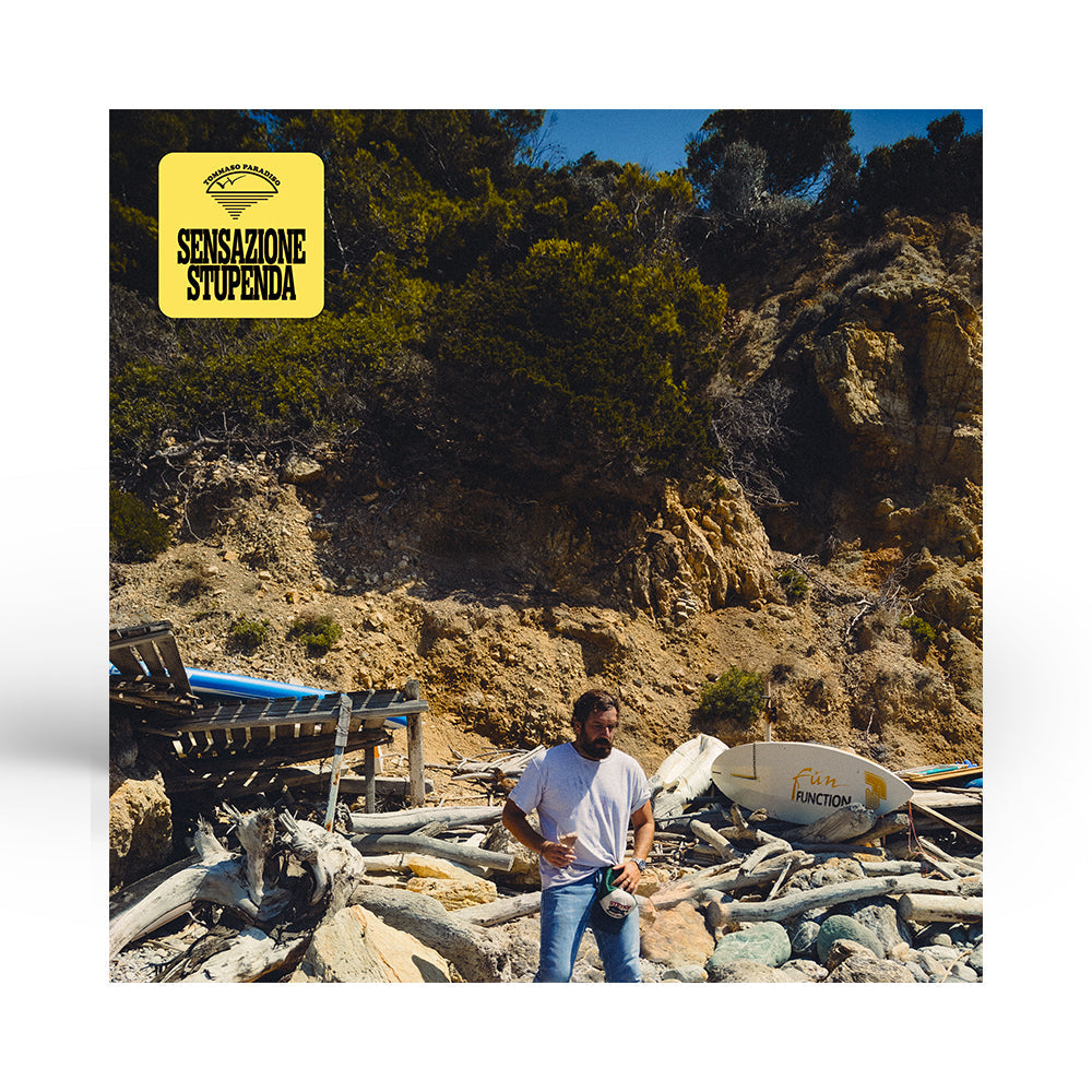 cover frontale del vinile nuovo album tommaso paradiso Sensazione Stupenda dove si vede un uomo in una spiaggia e sullo sfondo tavola da surf e legni